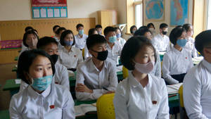 Professional in Medical Protective Gear Holding a Test Kit for Coronavirus — Chromebook Picha ya Ukuta