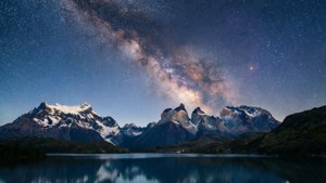 Milky Way juu ya mlima wa Patagonia iliyoreflect katika ziwa