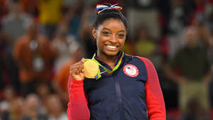 Picha ya mwenyekiti ya Simon Biles akitunukiwa medali ya dhahabu — iMac Picha ya Ukuta